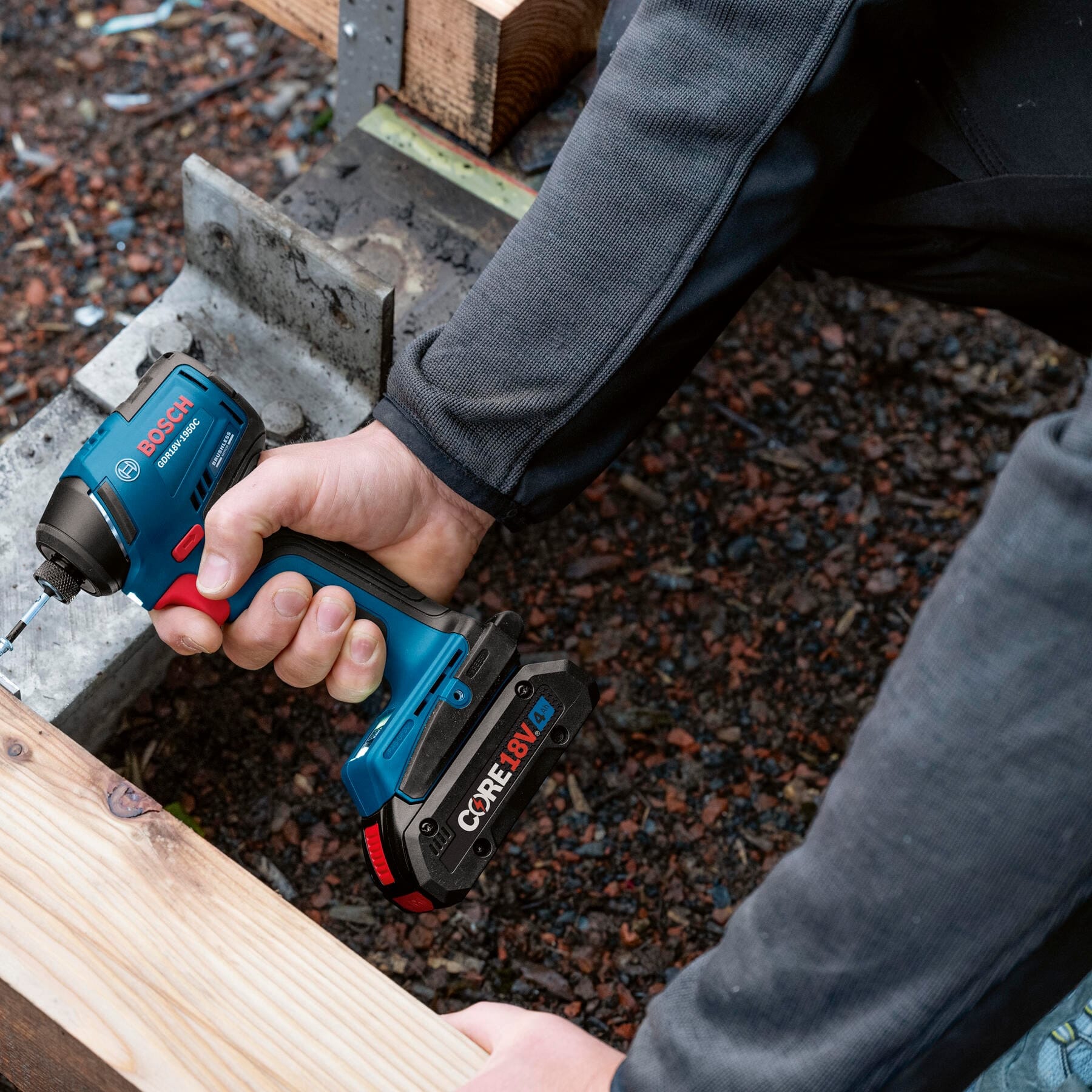 Contractor driving long framing screws into timber framing using the compact Bosch 18V brushless impact driver.