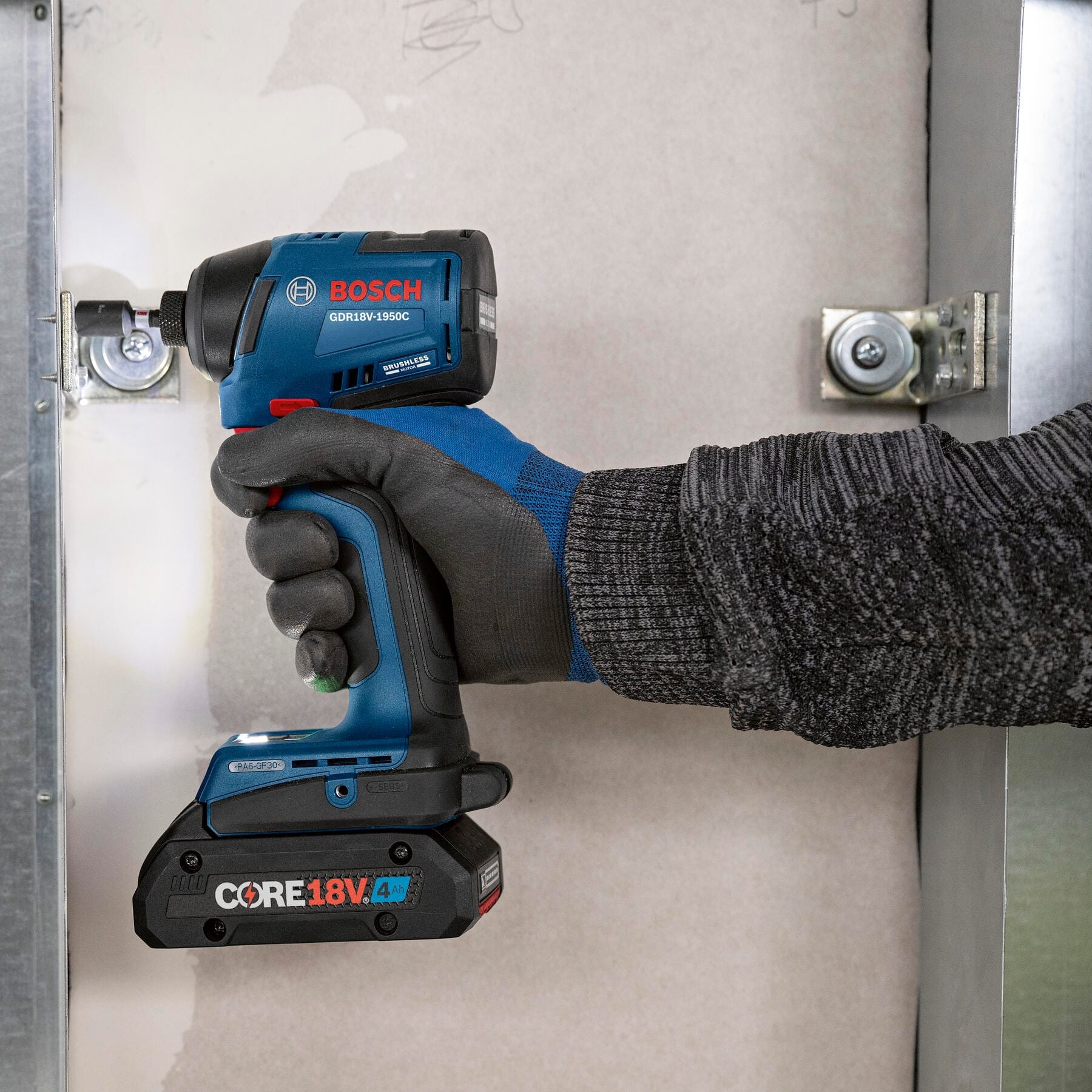 Bosch GDR18V-1950C fastening metal brackets in tight stud framing with a compact 4.45-inch head clearance.