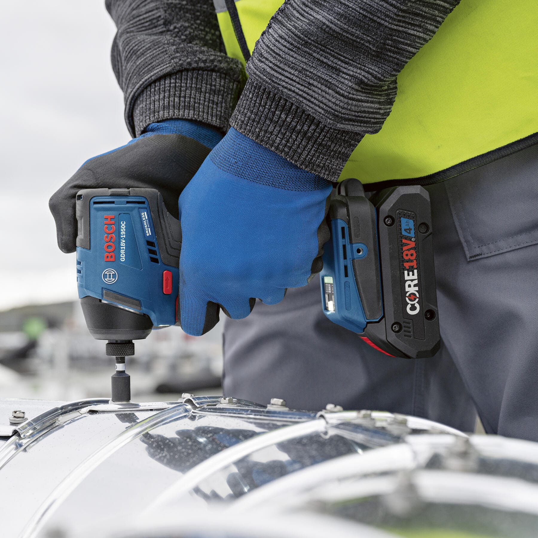Two-handed control driving sheet metal fasteners into ductwork using the high-torque Bosch 18V impact driver.