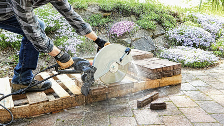 BOSCH DB1241S 12 in. Standard Segmented Rim Diamond Blade cutting bricks on a wet/dry saw outdoors.