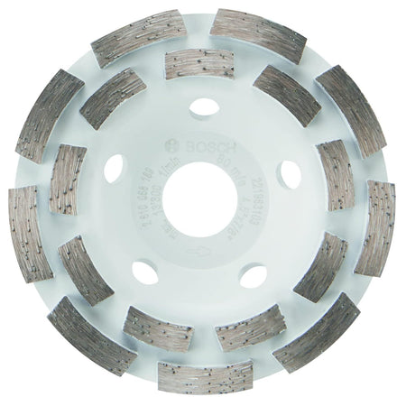 Product studio shot facing the front layout of the Bosch DC4518 4-1/2 Inch Double Row Segmented Rim Diamond Cup Wheel on a white background, highlighting its circular white steel base plate, a 7/8-inch center unthreaded arbor hole, surrounding airflow cooling vents, and 18 aggressively spaced double-row abrasive diamond grinding segments.