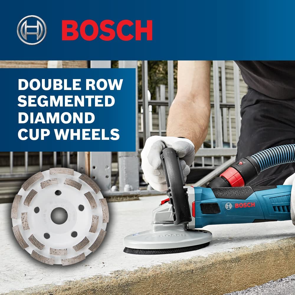 An application marketing graphic titled Double Row Segmented Diamond Cup Wheels, showing a worker using a blue corded Bosch angle grinder equipped with a surface dust shroud attachment and vacuum hose line to grind down a rough outdoor concrete steps curb line.