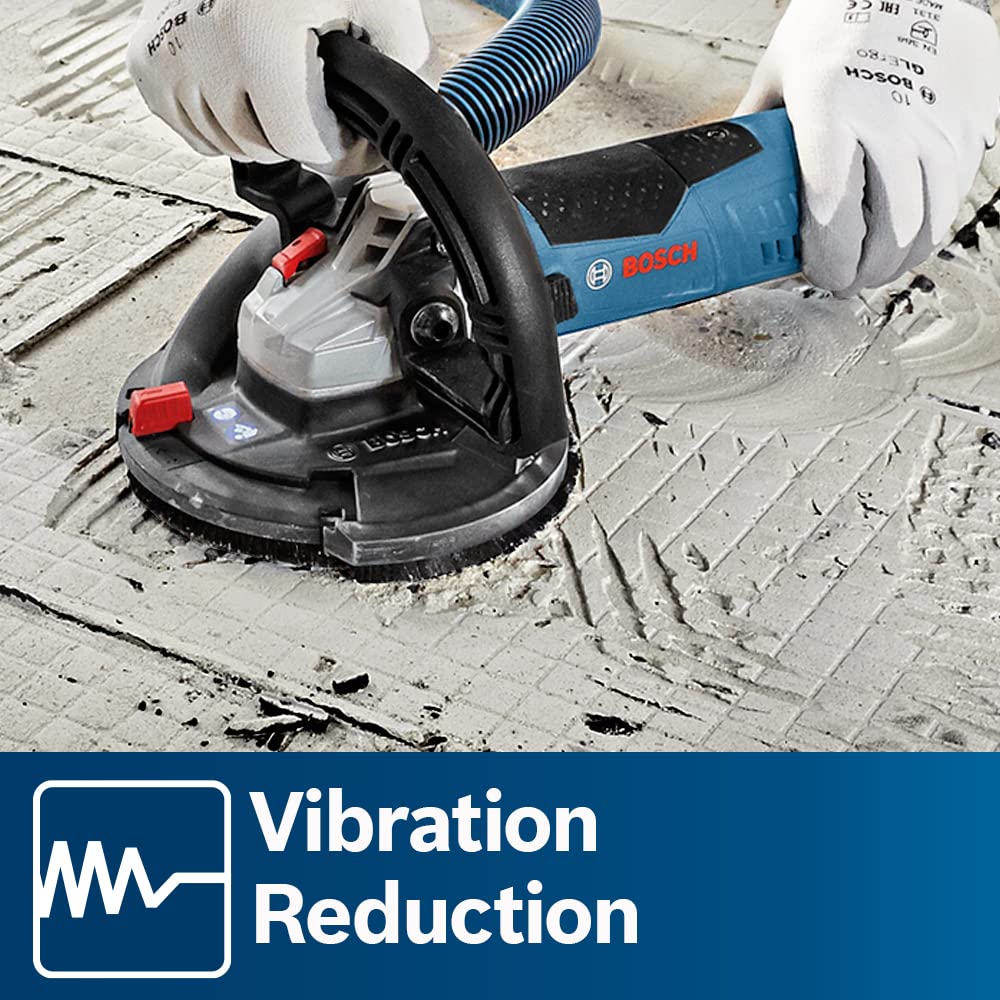 A close-up application shot of a technician wearing white safety gloves handling a handheld concrete surface grinder to flatten out an uneven floor covered in dried thinset tile adhesive grooves, with an official white wireline Vibration Reduction badge displayed on the bottom corner.