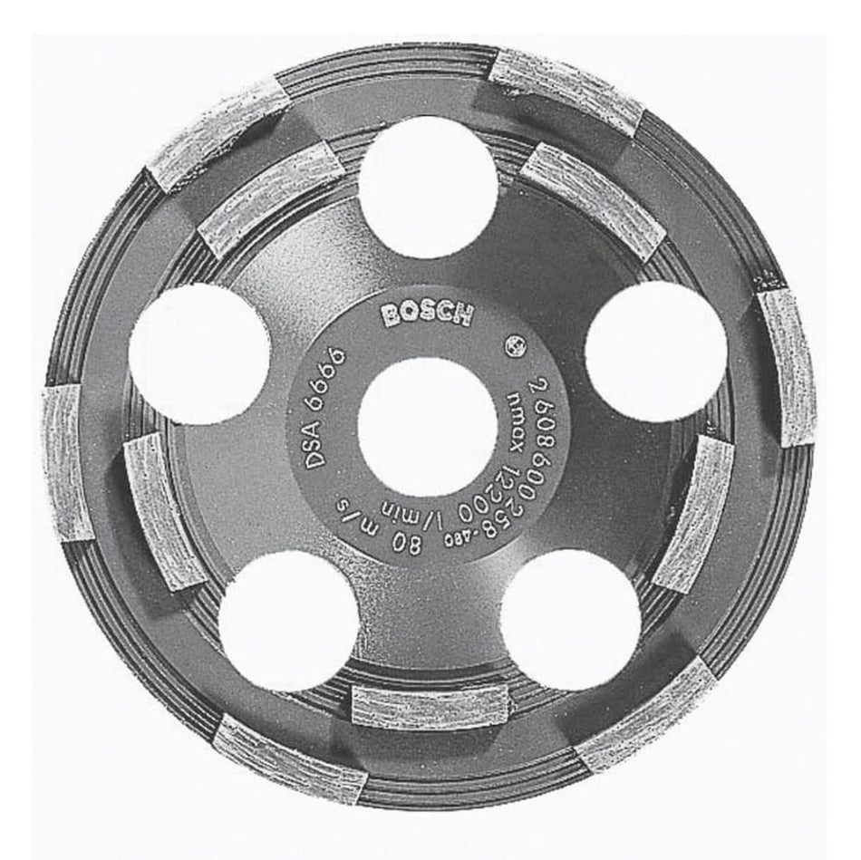 A studio display shot of the Bosch DC500 5-inch double row segmented diamond cup wheel against a white background, clearly illustrating its unthreaded 7/8-inch center arbor hole, six large round airflow cooling ports, and its abrasive diamond-embedded double row grinding segments engineered for low working temperatures and efficient coating removal.