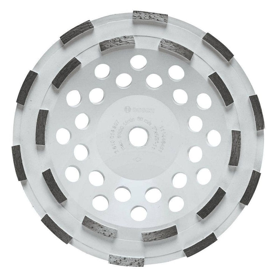 Product studio shot from a direct overhead view of the Bosch DC710H 7 Inch Double Row Segmented Rim Diamond Cup Wheel on a white background, displaying its wide white steel body, a 5/8-11 threaded center arbor hole, multiple concentric rings of round heat dissipation vents, and 12 aggressively arranged double-row segmented diamond cutting teeth.
