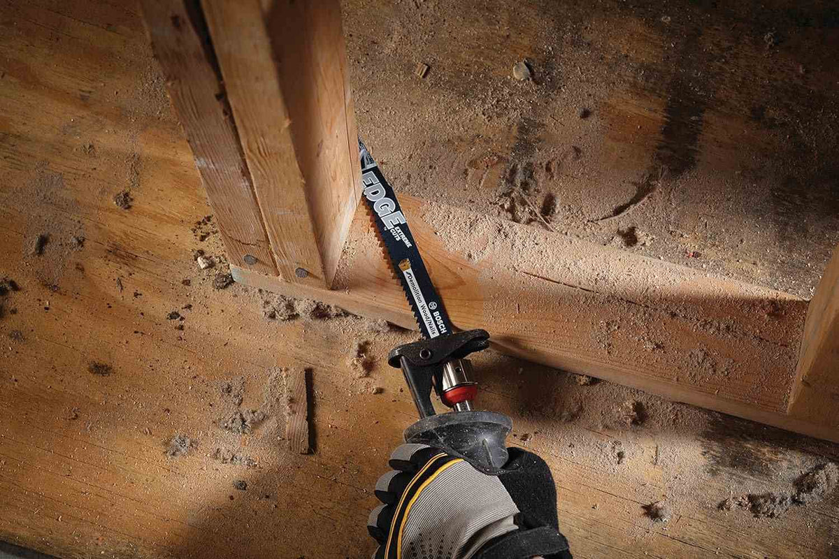 High angle action shot of the Edge blade cutting through a wooden stud plate to demonstrate its wood with nails demolition capability.