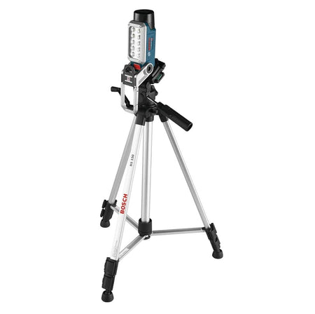 The Bosch FL12 LED worklight mounted vertically on a tall silver Bosch tripod using the integrated 1/4-inch screw thread for elevated jobsite lighting.