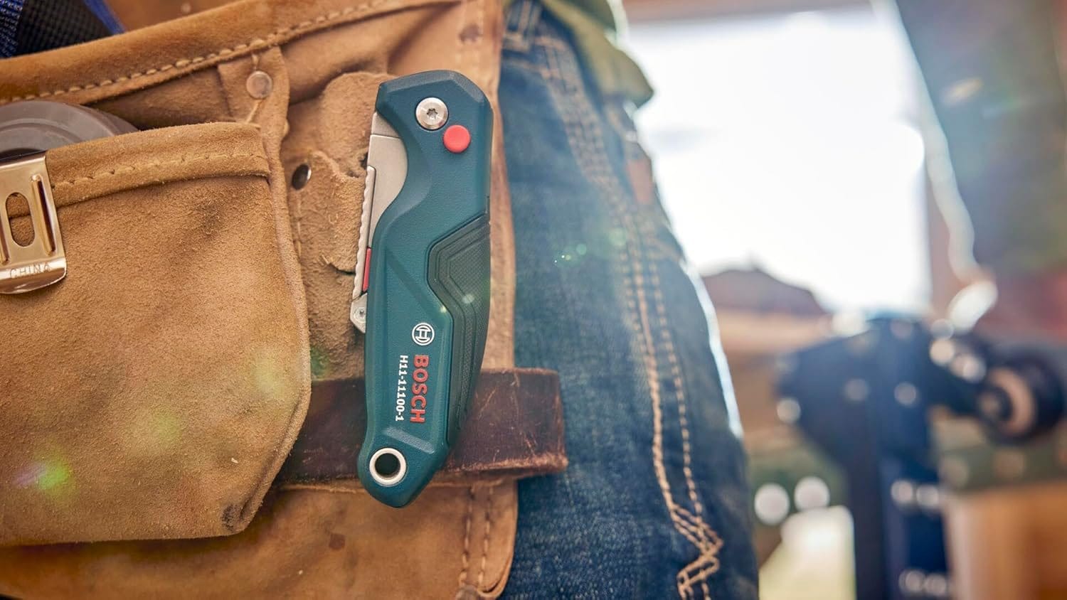 Close-up view of the folded utility knife securely attached to a tool belt pocket using the heavy-duty metal belt clip.