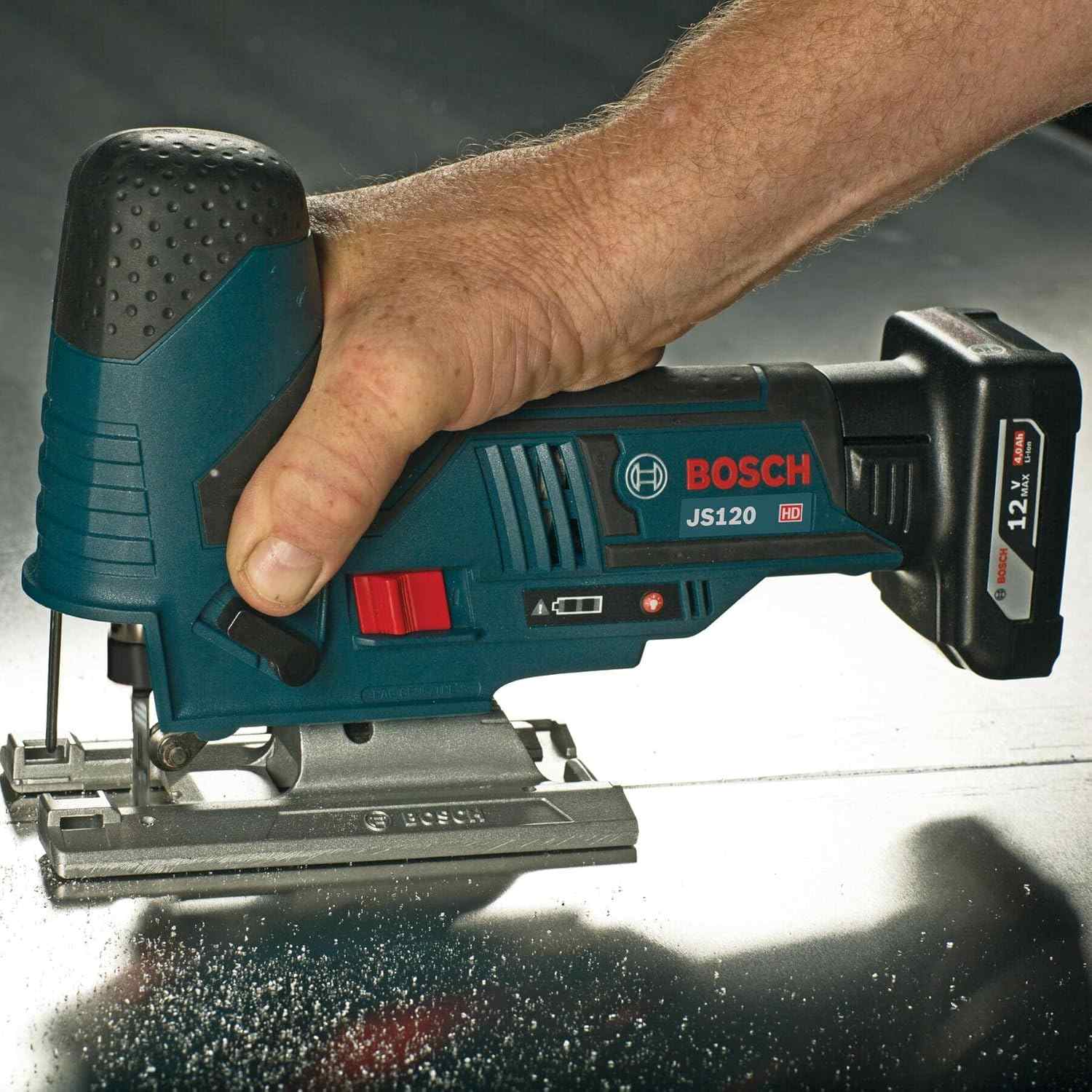 A close-up action shot of a person using a Bosch JS120 jigsaw powered by a 12V battery to cut through a metal surface.