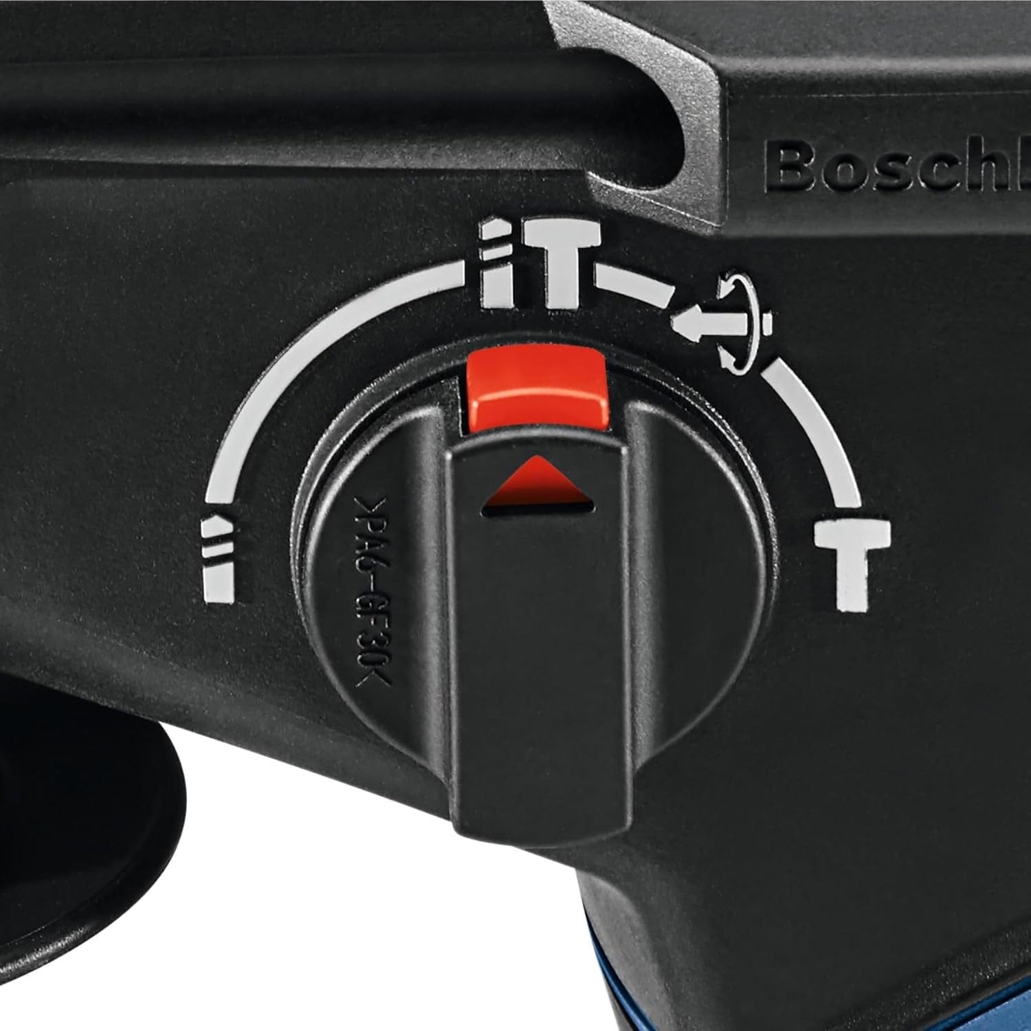 Person drilling into concrete wall with Bosch rotary hammer connected to dust extraction hose; construction site interior visible.