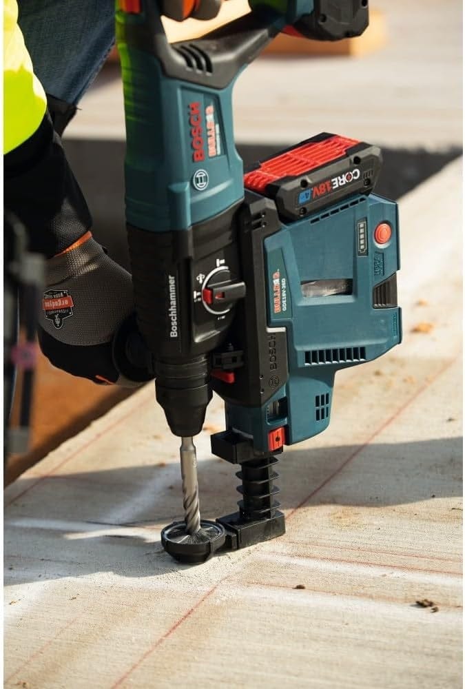 A detailed view of the Bosch 18V Bulldog rotary hammer equipped with an integrated HEPA dust extractor, demonstrating the tool's ability to maintain a clean workspace while drilling into concrete.