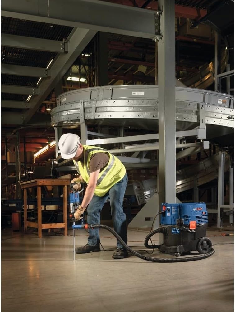 Professional using the Bosch Bulldog rotary hammer for downward floor drilling on a job site, highlighting the tool's effectiveness in heavy-duty commercial applications.