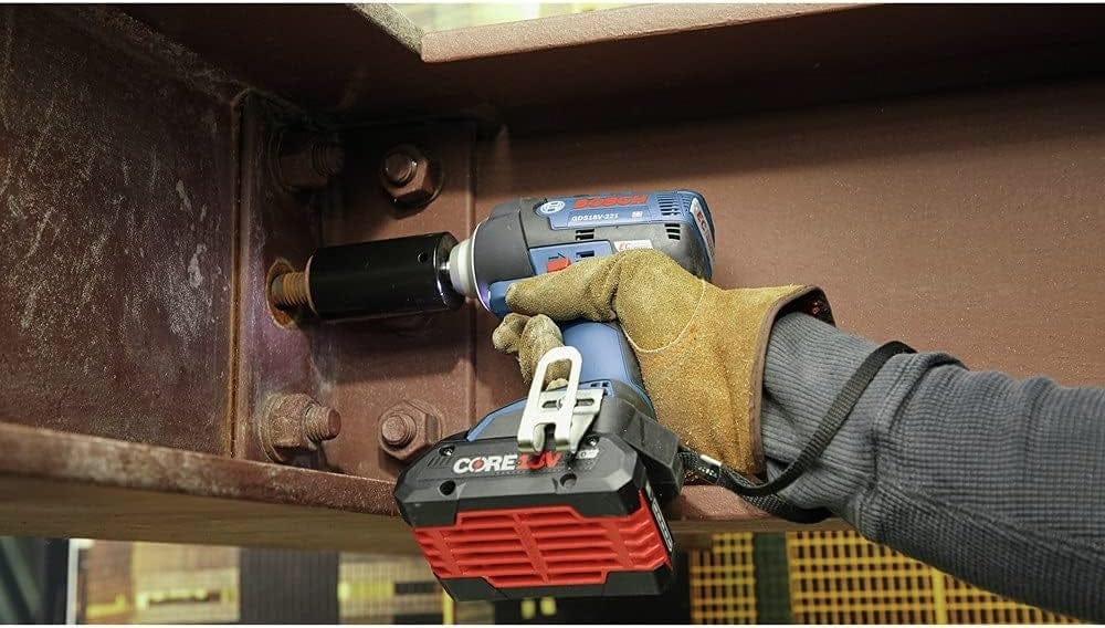 Worker using a Bosch GDS18V‑745C 18V cordless impact wrench to tighten a bolt on a steel beam, demonstrating high‑torque fastening power, CORE18V battery performance, and rugged jobsite durability for structural and industrial applications.
