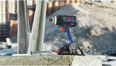 Bosch GDS18V‑221 18V EC Brushless impact wrench positioned upright on a construction site with steel fasteners nearby, showcasing durable design, CORE18V battery power, and high‑torque capability for heavy‑duty fastening tasks.