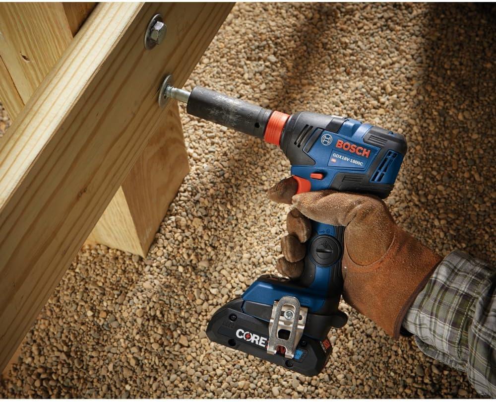An action shot of a worker using the hybrid impact tool with a socket to drive a large bolt into a heavy-duty wooden structural beam outdoors.