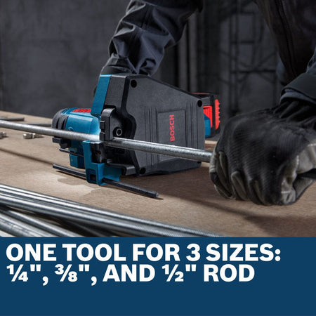A close-up application shot focusing on the industrial cutting jaws of the Bosch GGC18V-12N cordless threaded rod cutter resting flat on a wooden fabrication bench. The image showcases a steel rod nested perfectly within the internal mechanical shearing dies, paired with a lower text graphic stating One tool for 3 sizes: 1/4", 3/8", and 1/2" rod.
