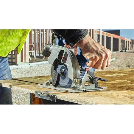 Worker in high-visibility vest using Bosch circular saw at construction site; guiding tool through wood surface.
