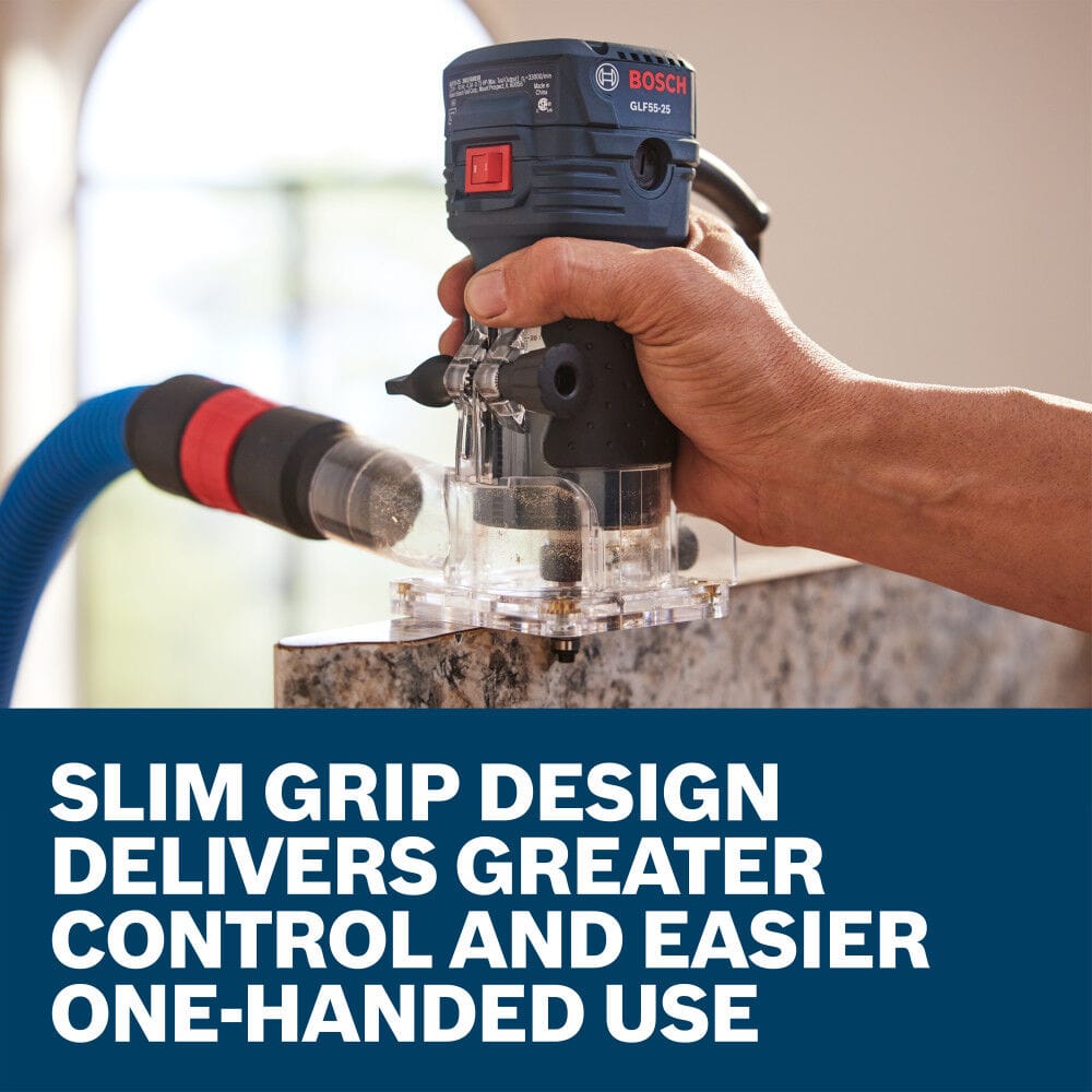 A close-up action view of a finish carpenter using one hand to guide the Bosch GLF55-25 fixed-base trim router along the edge of a custom countertop material sheet. An attached blue vacuum extraction hose collects wood debris in real time, accompanied by a lower text box reading Slim grip design delivers greater control and easier one-handed use.