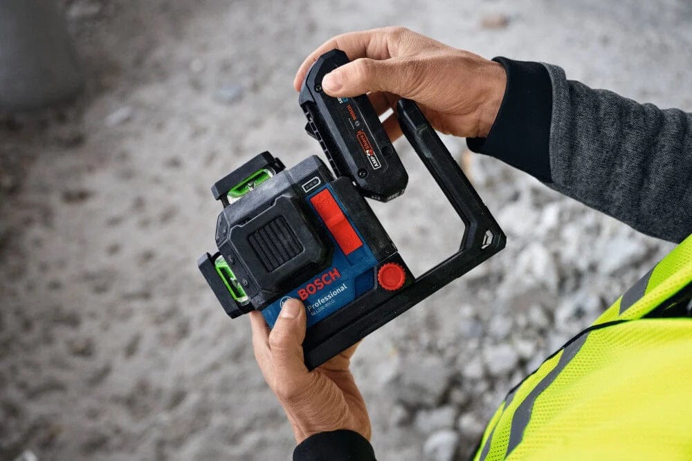 Close-up view of a user holding the laser level and sliding the rechargeable battery into place