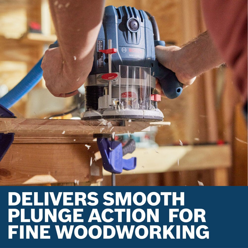 A carpenter utilizing the Bosch GOF13-25 1-3/4 HP mid-size plunge router to mill out a precise decorative trim edge line along a wooden workbench board clamped securely to a workstation base. The close-up view captures wood shavings spraying from the transparent sub-base cutting window, set above a lower marketing banner reading Delivers smooth plunge action for fine woodworking.