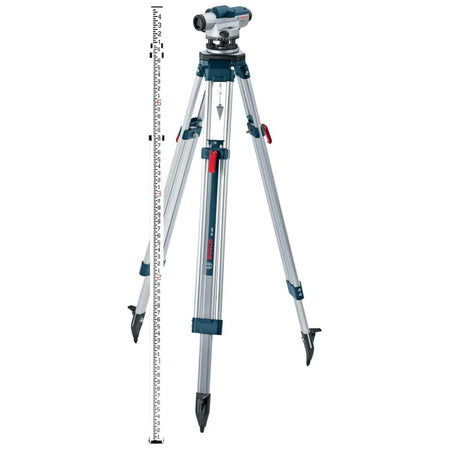 Product studio shot from a full-length perspective of the Bosch GOL26CK automatic optical level instrument mounted securely on a silver aluminum contractor tripod with a metal plumb bob hanging centrally beneath the head, standing next to a vertical telescoping white and red centimeter-graduated leveling grade rod.