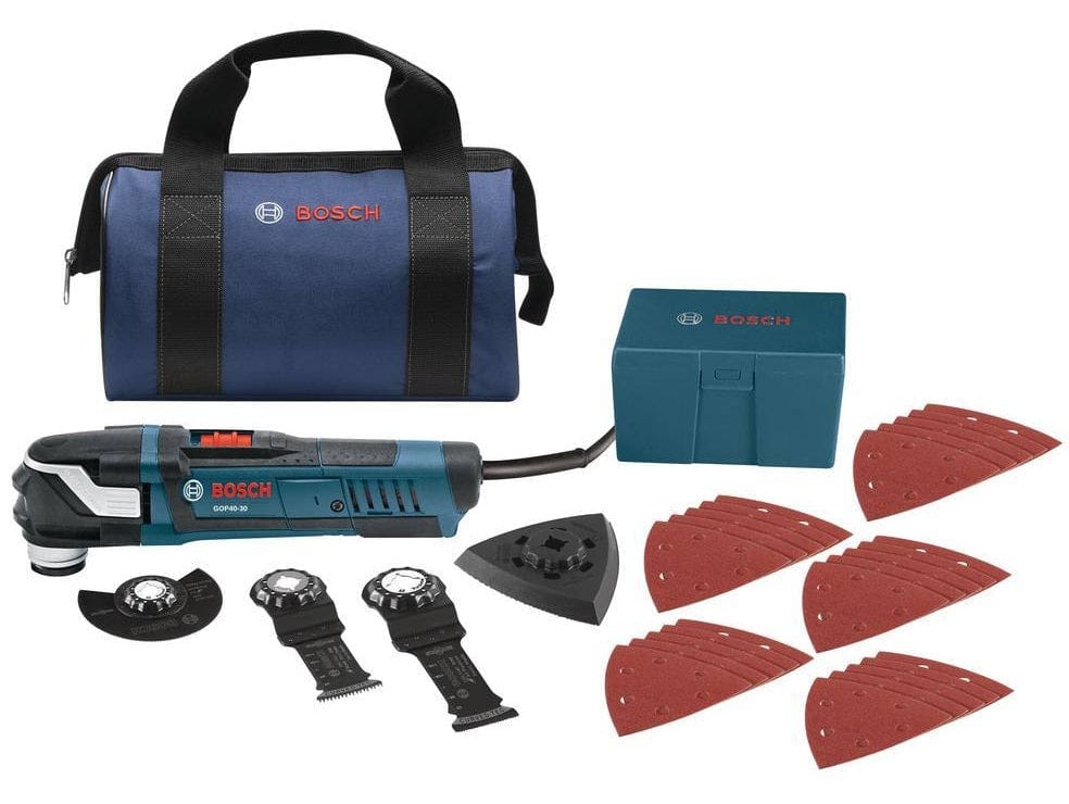 Bosch GOP40-30 multi-tool kit with carrying bag, accessory box, sanding pads, and cutting blades arranged on surface.