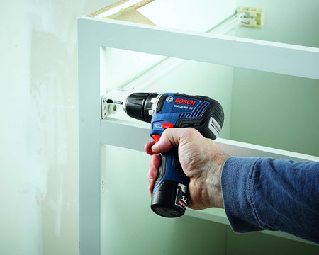 The Bosch 12V Max brushless drill/driver displayed with its included professional accessories: a magnetic four-tip bit holder, Impact Tough driver bits, and a silver belt clip.