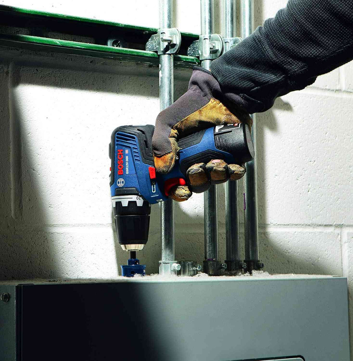 Action shot of a professional using the Bosch GSR12V-300N for an overhead fastening application, demonstrating the tool's 1.6-pound lightweight design and maneuverability.