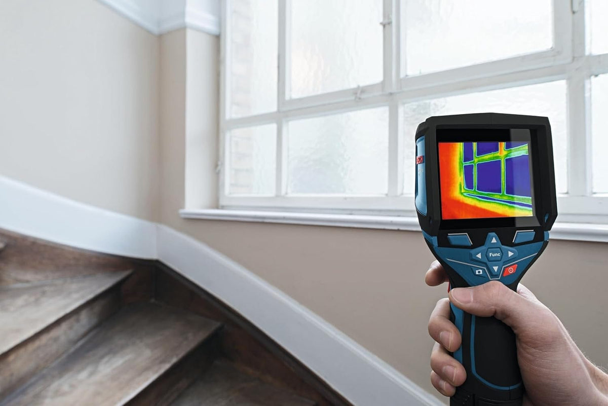 The thermal camera scanning a window area to detect heat loss or insulation gaps around the frame