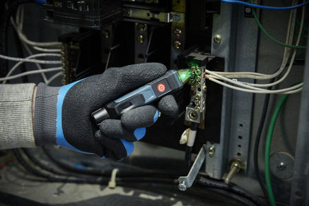 A real-world maintenance application showing a gloved technician using the Bosch GVD1000-15 circuit detector stick to inspect a neutral grounding bus terminal block inside an electrical panel box. The transparent indicator tip glows green, verifying a safe, de-energized connection before running structural repairs.