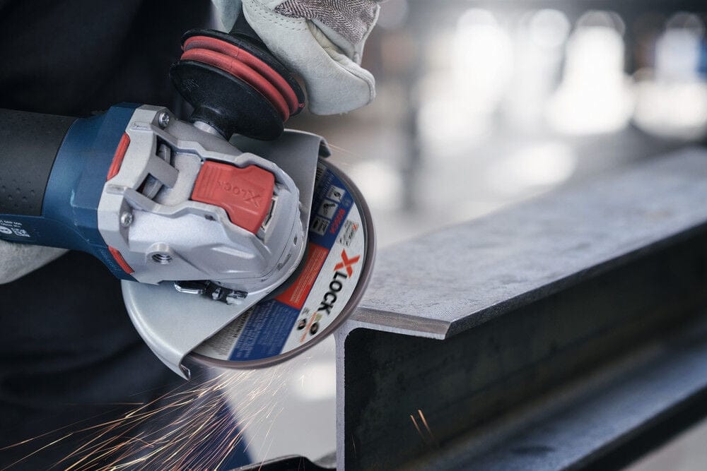 Action shot showing the Bosch X-LOCK grinder cutting through rebar with a thin abrasive wheel, demonstrating high-speed metal cutting.