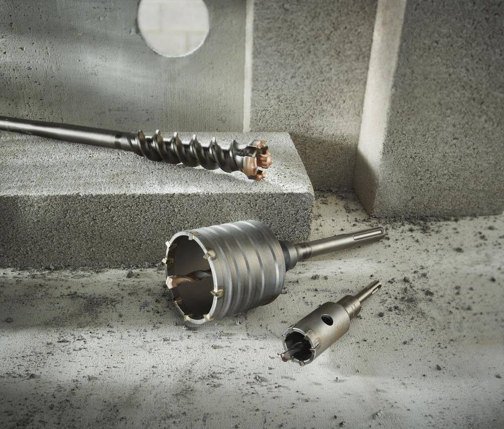 Studio arrangement of various Bosch concrete drilling accessories including a large SDS-max core bit with the HC88 centering pin installed, alongside other bits on a concrete block.