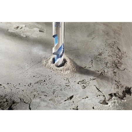 An action shot showing the Bosch hammer drill bit as it bores into a concrete surface, demonstrating effective dust removal from the hole during use.