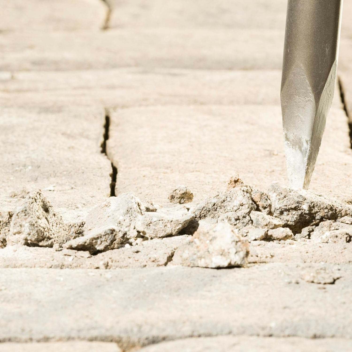 A detailed close-up of the Bosch R-Tec bull point tip fracturing a concrete surface, demonstrating the high-energy reflection technology that increases breakout efficiency and reduces user vibration.