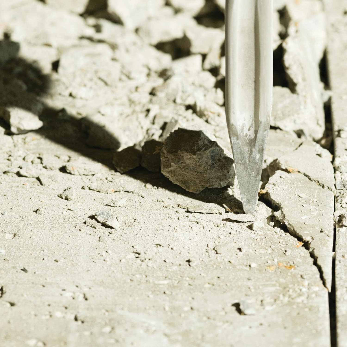 A high-impact perspective of the Bosch 16-inch star point chisel bit penetrating a concrete surface, showcasing the self-sharpening twist flutes that prevent binding during aggressive demolition.