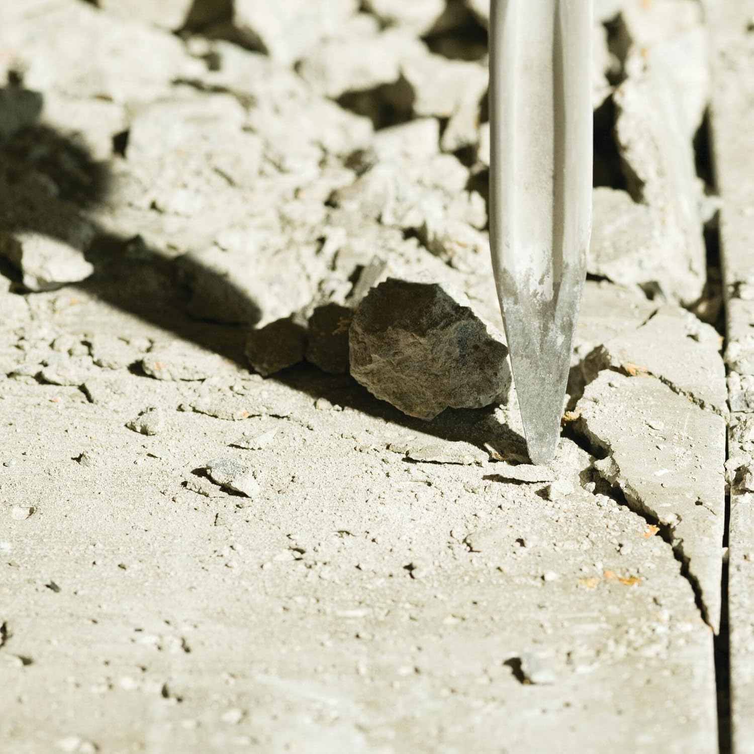 A high-impact perspective of the Bosch 16-inch star point chisel bit penetrating a concrete surface, showcasing the self-sharpening twist flutes that prevent binding during aggressive demolition.