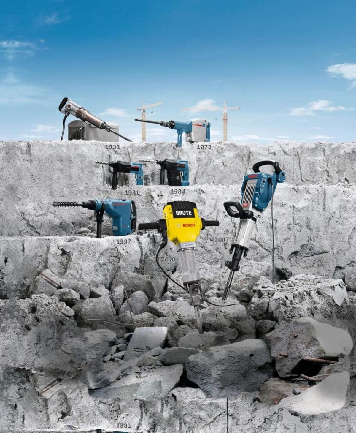 Bosch brand heavy duty demolition hammers and industrial rotary drills displayed on concrete steps at a job site featuring structural historical year labels spanning 1932 to 2010 beside a Brute electric breaker hammer.