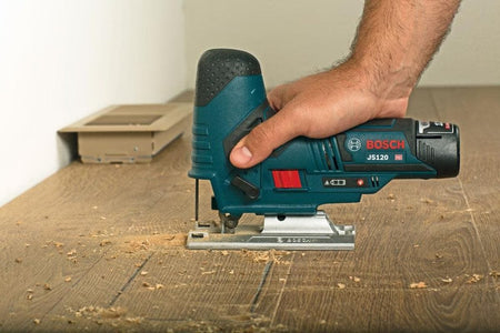 A detailed application shot of the Bosch JS120N-RT cutting through hardwood flooring, highlighting the smooth operation and reduced user fatigue provided by the smallest grip diameter in its class.