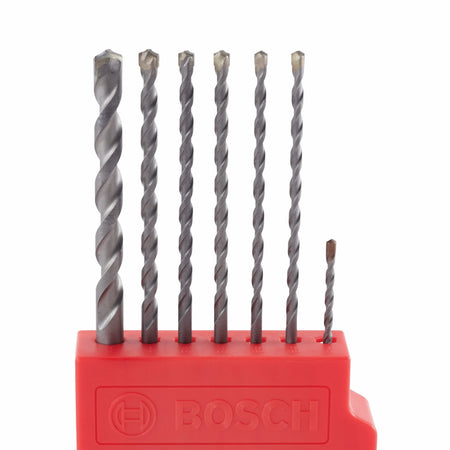 A close-up catalog shot capturing the Bosch LBHXS7U impact-rated masonry drill bits arranged neatly inside an open red plastic organizer index base. Standing vertically against a clean white backdrop, the layout clearly highlights the progressive step-down in sizing across the silver steel bit flutes and industrial-grade carbide tips.