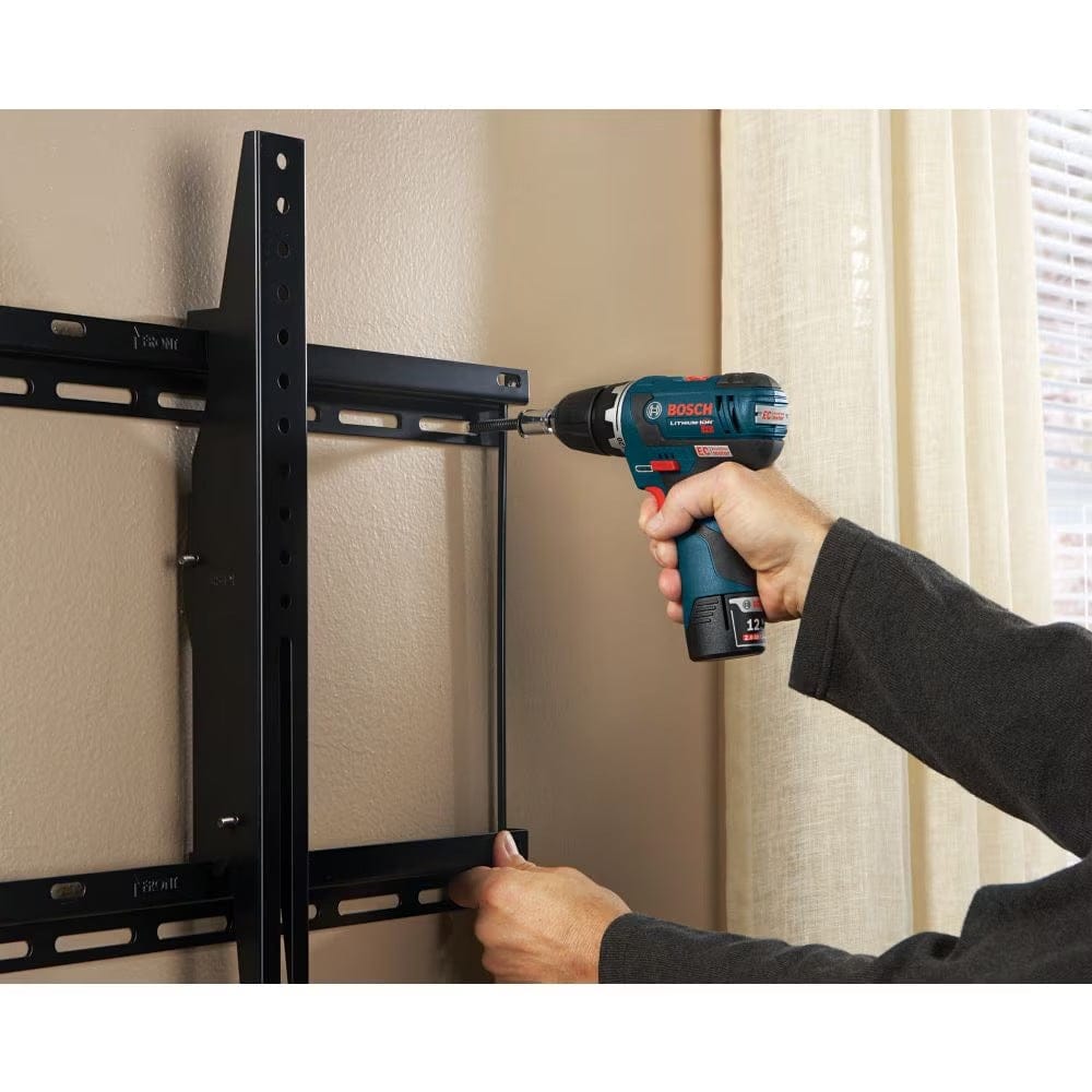 A person using a Bosch 12V Max cordless drill and a socket from the MS4034 mixed set to fasten a black metal television wall mount bracket.