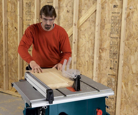 A professional craftsman utilizing a table saw with the Bosch 12-inch 80-tooth finishing blade to rip a solid wood board, emphasizing the blade's anti-friction coating for reduced heat and clean, accurate cuts.