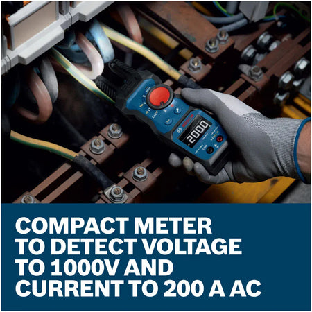 A close up view of an electrician using the open fork jaw of the Bosch PRO GFM1000-15 electrical multi tester to non invasively check a circuit breaker line wire. The built in LED flashlight illuminates the tight wiring, with text stating Compact meter to detect voltage to 1000V and current to 200 A AC.