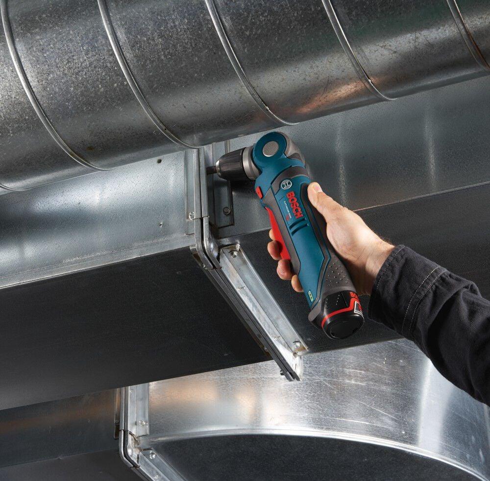 Action shot showing the right angle drill being used to reach into a tight space to drive a screw into a metal HVAC duct connection.