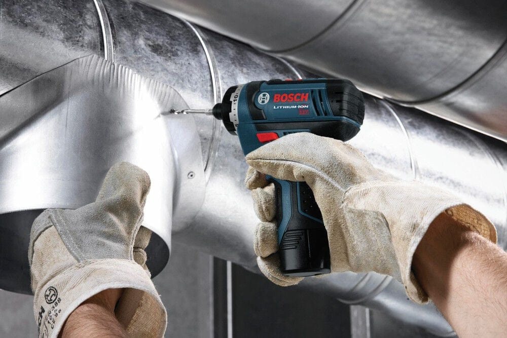 An action shot of the pocket driver being used in an overhead application to secure a metal bracket, highlighting its lightweight design and reduced user fatigue.