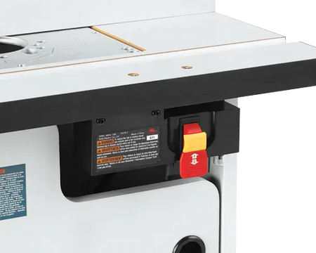 A close-up profile view of the front right corner of the router table, highlighting the laminated top plate, accessory slot, and the master electrical safety power switch with its prominent red paddle and yellow lock-out key.