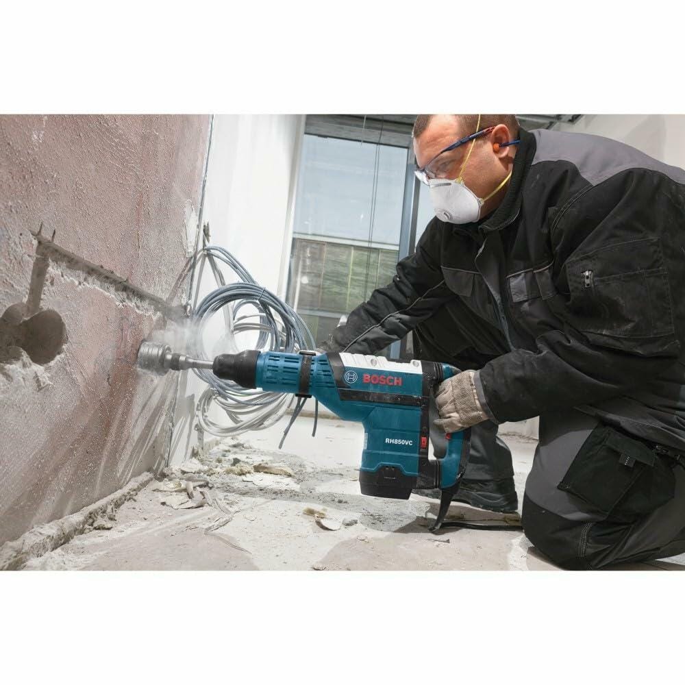 A worker uses the Bosch RH850VC hammer with a large core bit to drill horizontally through a concrete wall.