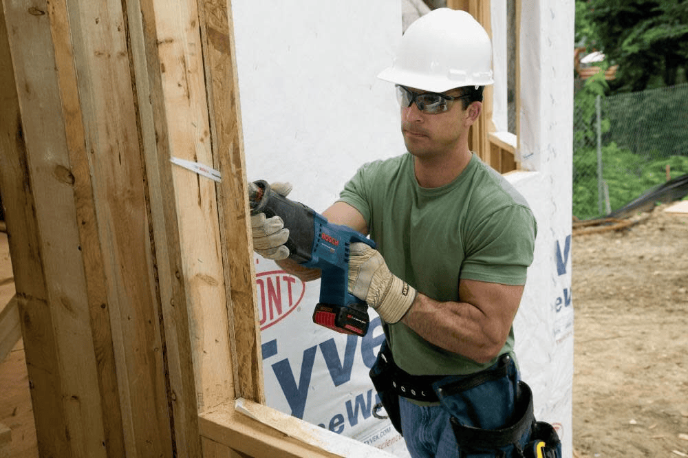 Professional construction contractor wearing safety gear using a Bosch cordless reciprocating saw and RPRAP6 Edge bi-metal blade for fast, precision cuts in wood framing.