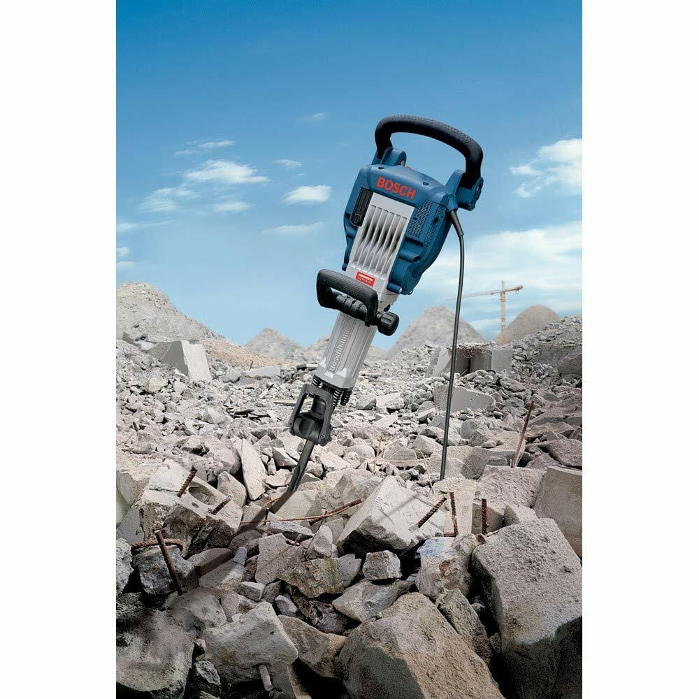 The Bosch Jack breaker hammer standing powerfully in a large pile of broken concrete rubble on an outdoor demolition site.
