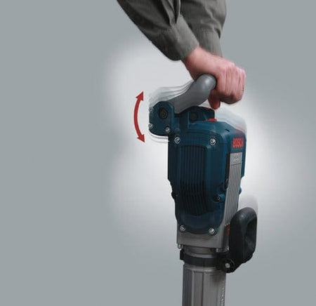 Close-up demonstrating the Vibration Control feature of the Bosch breaker hammer's top handle, with an arrow showing its shock-reducing motion.