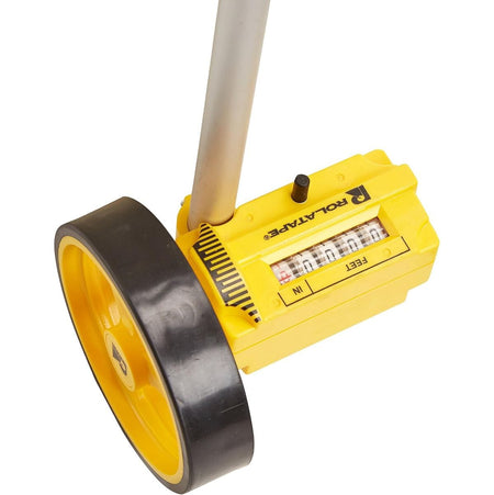 A close-up view of the mechanical measurement mechanism on the Bosch Rolatape RT104 single measuring wheel tool, highlighting the yellow protective housing with the official Rolatape logo, a top-mounted black reset button, and a clear plastic viewport screen displaying the physical mechanical rolling wheels calibrated to measure in feet and inches.